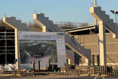 Die Westtribüne am 27. März 2025. Das Baustellenschild wird am Haupteingang montiert.